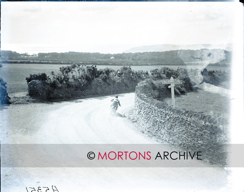062 Plate 06 
 Wilson (New Imp) at Signpost Corner. Note the road surface... 
 Keywords: 1925, Amateur TT, Glass plate, Mortons Archive, Mortons Media Group, Straight from the plate