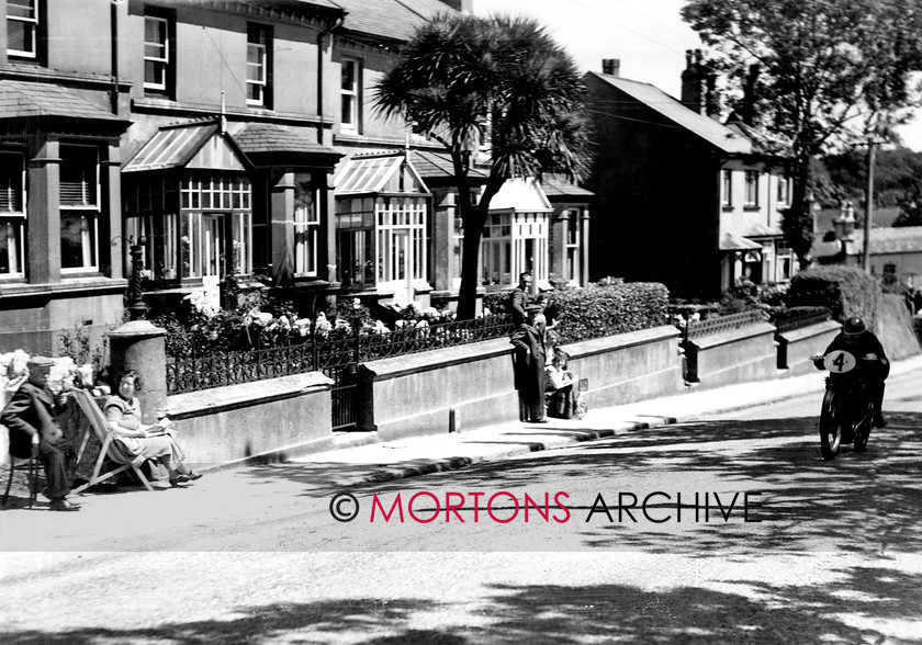 Manx 18A 
 18A – CF Brett flies through Crosby as the locals enjoy the view. 
 Keywords: 2012, Exhibition of historic images, Manx Grand Prix, Mortons Archive, Mortons Media Group, Mountain Milestones - Memories from Mona's Isle