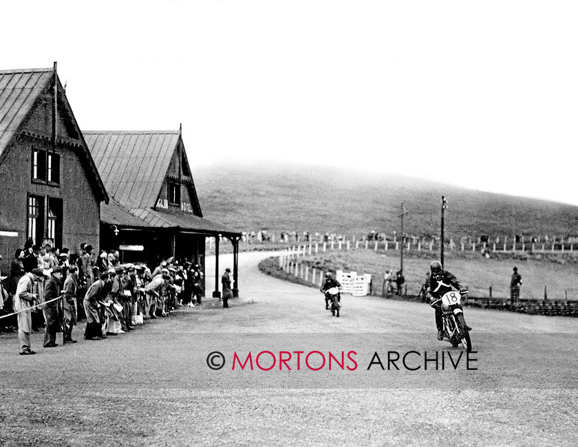 Manx 18B 
 18B – Hard to believe but the Bungalow building was still there into the fifties. Here PR Warren and C Tattershall do their best to avoid it. 
 Keywords: 2012, Exhibition of historic images, Manx Grand Prix, Mortons Archive, Mortons Media Group, Mountain Milestones - Memories from Mona's Isle