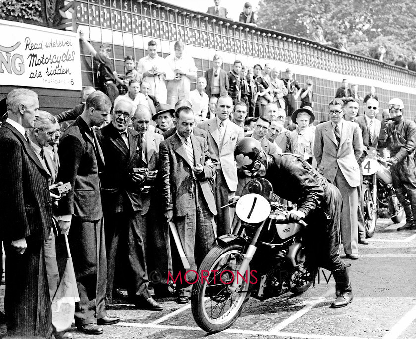 Manx 14A 
 16A – Artie Bell pushes off to start the 1949 Senior under the watchful eye of the Duke of Edinburgh, fourth from left. 
 Keywords: 2012, Exhibition of historic images, Manx Grand Prix, Mortons Archive, Mortons Media Group, Mountain Milestones - Memories from Mona's Isle