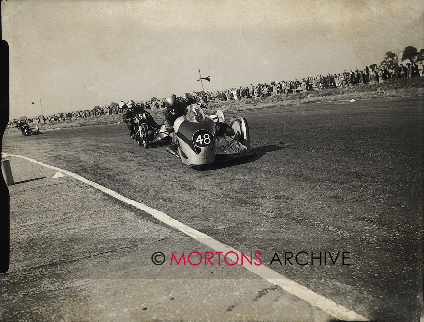 hutchinson 15470-26 
 Norton's Eric Oliver, two-times a winner on the day leads like-mounted double runner-up Cyril Smith. 
 Keywords: 1953, Hutchinson 100, May 11, Mortons Archive, Mortons Media Group, Silverstone, Straight from the plate, The Classic MotorCycle