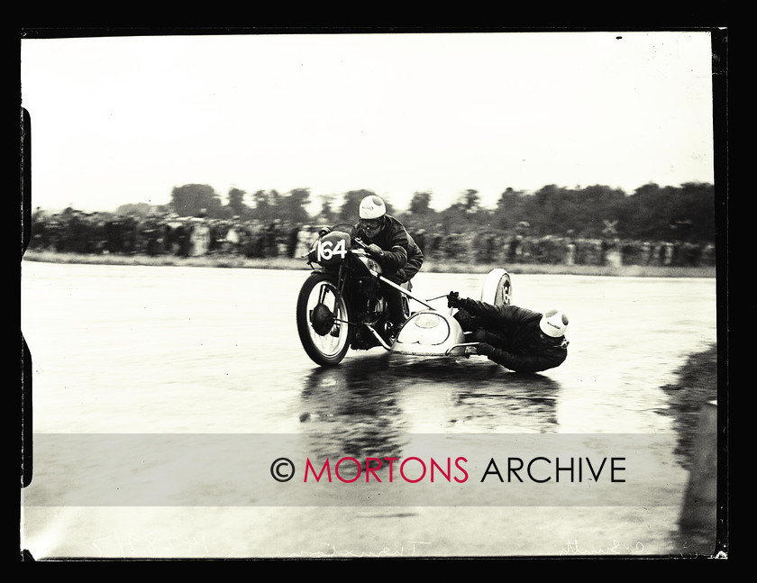 053 SFTP 1951 Thruxton A02 
 Wet day at Thruxton, August 1951 - Sidecar winners Cyril Smith/Bob Clements power round Club Corner, in a beautifully controlled slide. 
 Keywords: 2014, April, Glass Plates, Mortons Archive, Mortons Media Group Ltd, Straight from the plate, The Classic MotorCycle, Thruxton