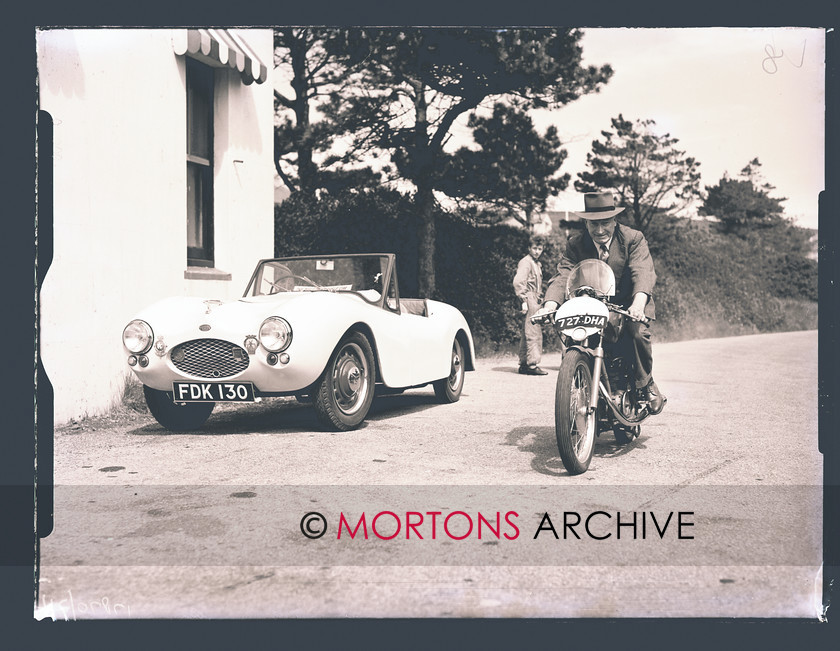SFTP TT Practice 1957 02 
 Frank Cope on his 125cc MV, complete with road number plates. The car a sports 'Milburn' badge on the bonnet, a VMCC badge on the grill and the slogan @The build it yourself car in the windscreen. 
 Keywords: 1957 Practice TT, Issue, Mortons Archive, Mortons Media Group, October 2011, Straight from the plate, The Classic MotorCycle