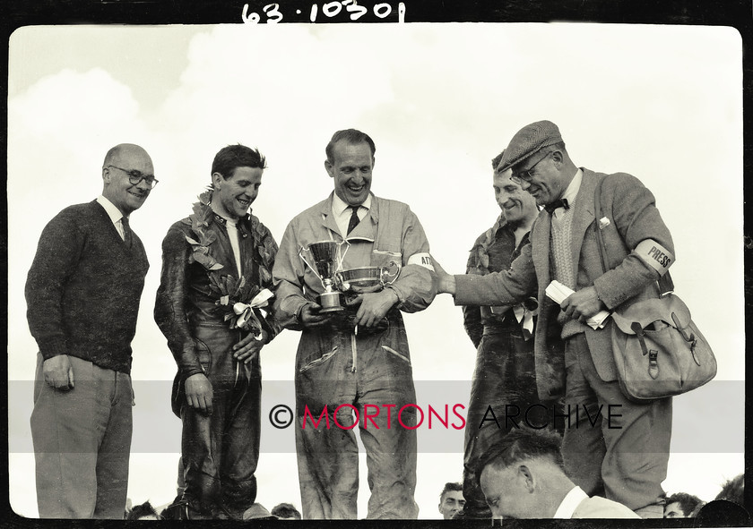 062 glass plate 08 
 Syd Lawton holds the The Motor Cycle Trophy and replica while the two riders Phil Read (left of Syd) and Brian Setchell (right) wear their winner wreaths around their neck. Neville Goss stands on the far left and Harry Louis on the far right. 
 Keywords: 1963, 2013, Glass plate, June, Mortons Archive, Mortons Media Group, Straight from the plate, The Classic MotorCycle, Thruxton 500 mile race